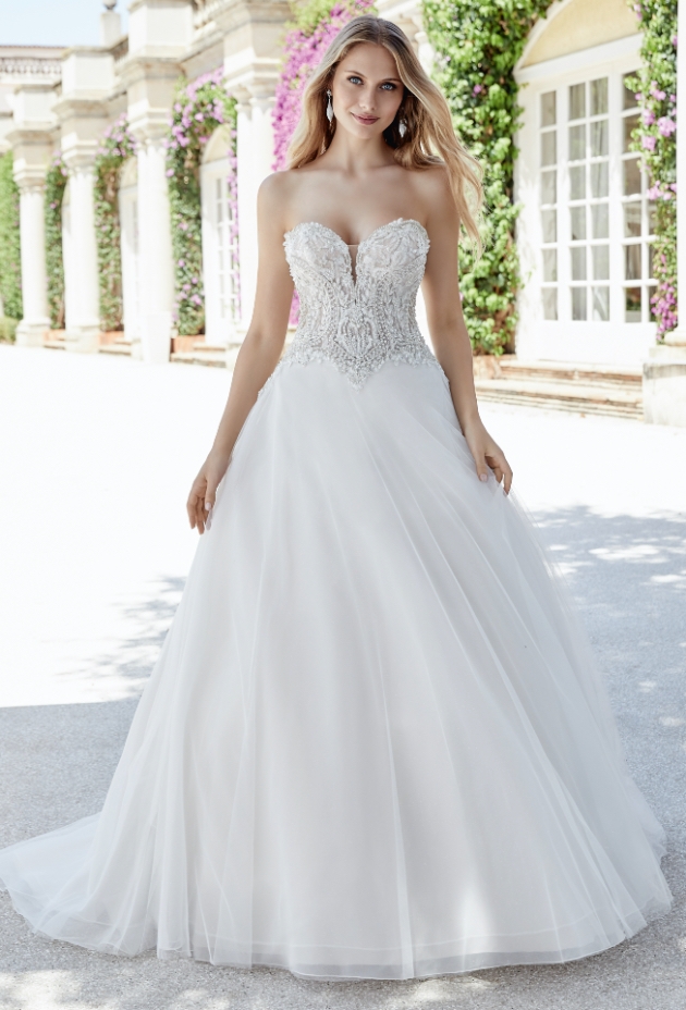 Blonde bride in wedding dress with lace bodice and full skirt.