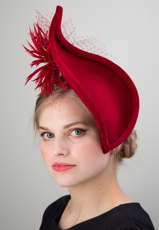 Woman wearing large red fascinator.