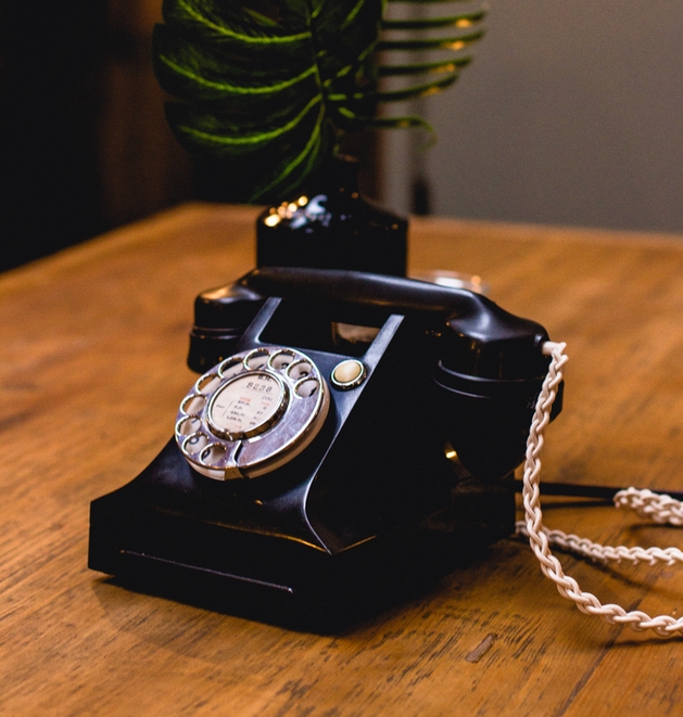 Bakelite style phone guest book on vintage desk.