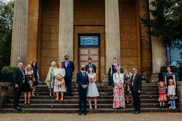 Intimate wedding party wearing face masks outside Arnos Vale wedding venue in Bristol.