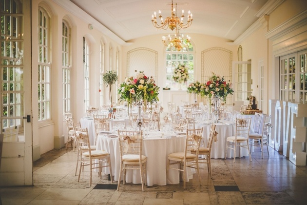 Interior of The Orangery at Goldney House set up for a wedding breakfast with round tables and flowers