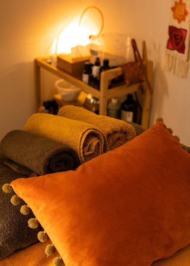 Treatment room with cushions and towels at The Kind Living Salon.