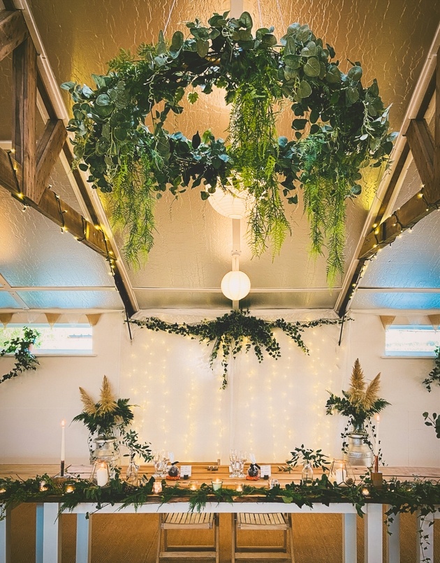 Wedding table with natural styling, foliage and hanging floral hoop.