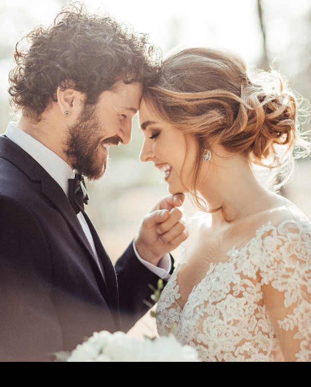 smiling bride and groom foreheads touching