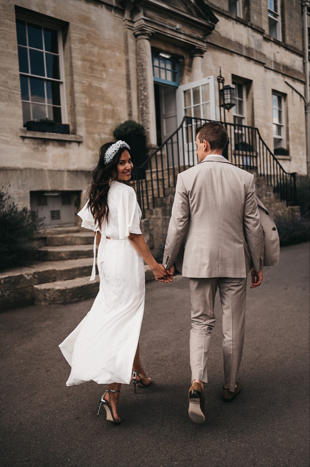 Bride and groom walking hand in hand towards The Painswick