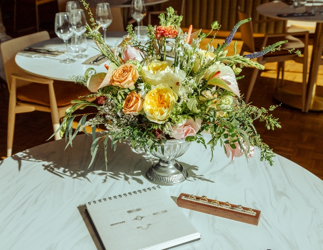 Flowers on a table with wedding rings in the foreground