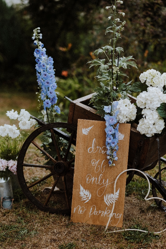 bicycle adorned in blue and white flowers with no parking sign for a wedding.