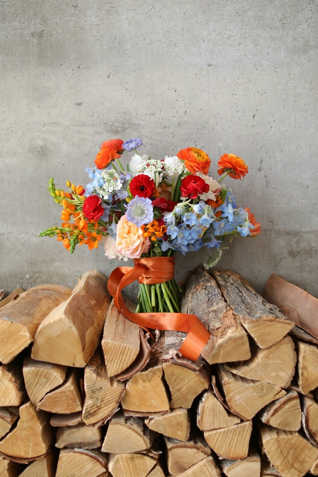 wildflower bouquet sat on wood pile