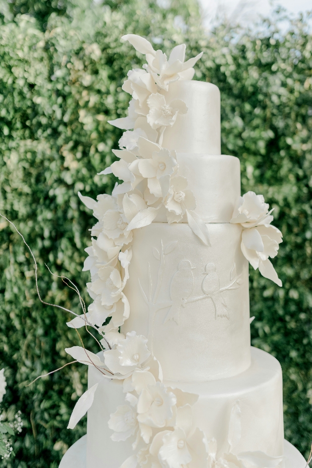 all white wedding cake with sugar flower decoration