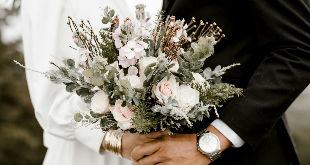 Bride and groom holding a bunch of flowers
