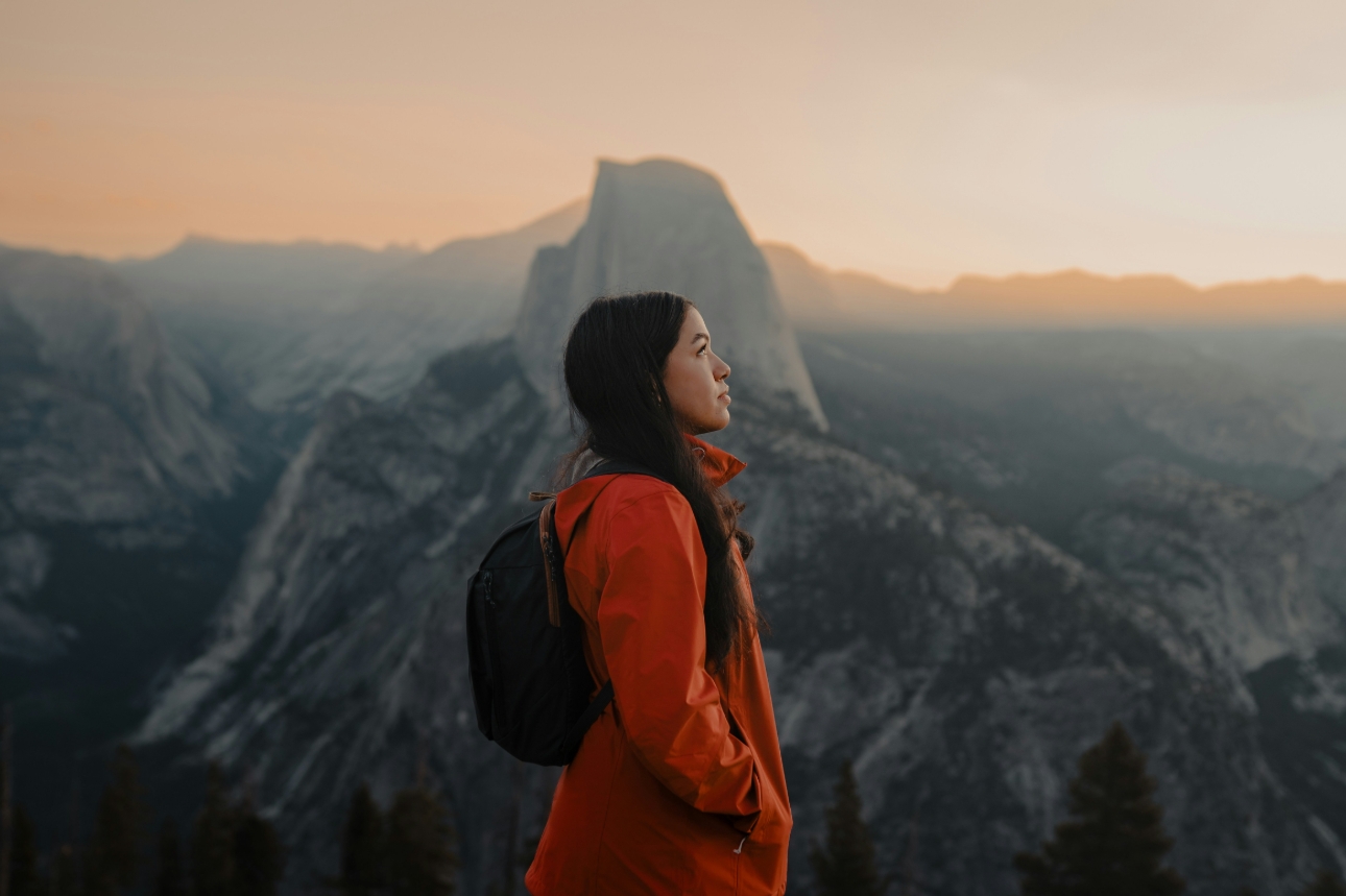 woman stood at the top of a mountain at sunrise