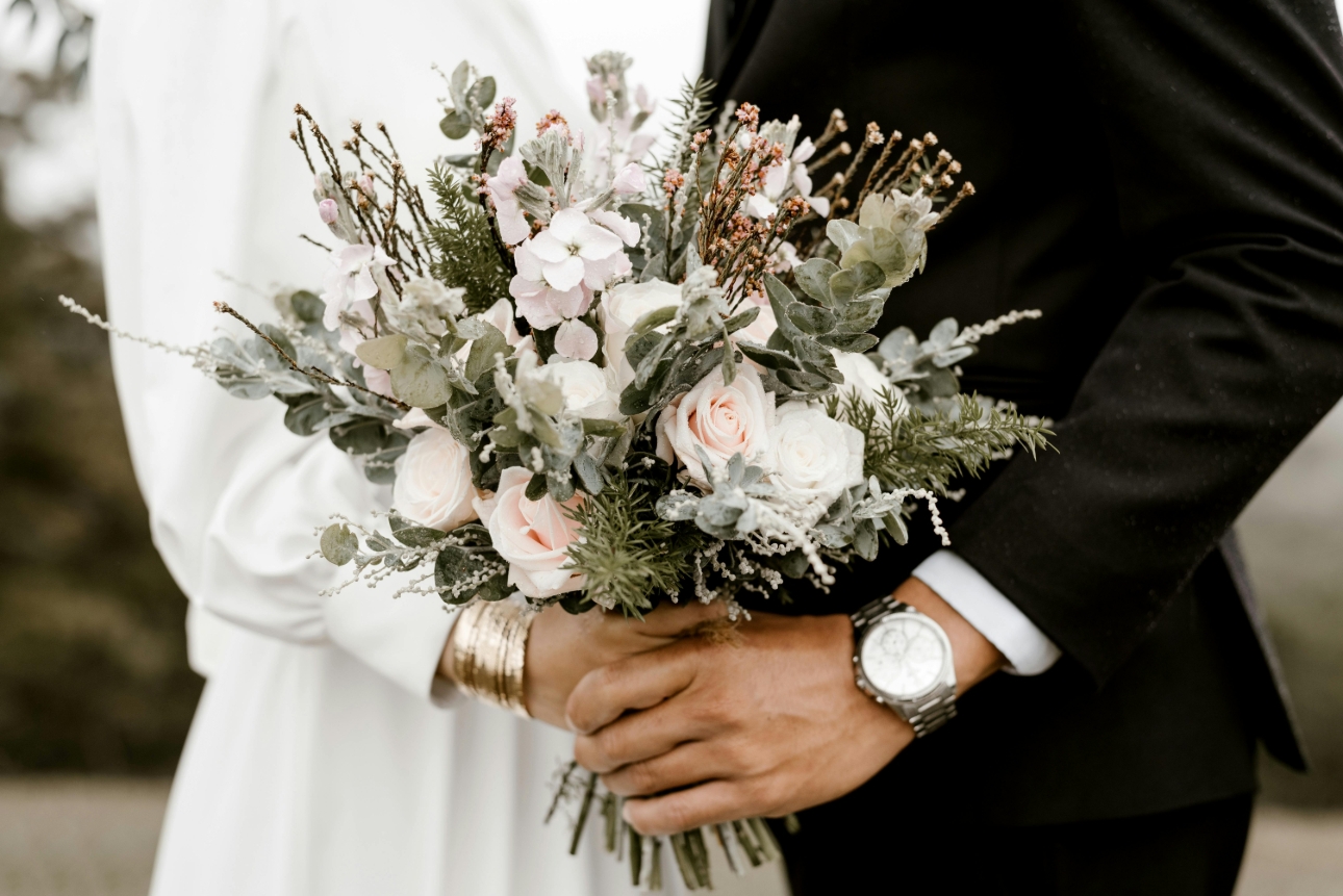 bride standing with grooms holding bouquet